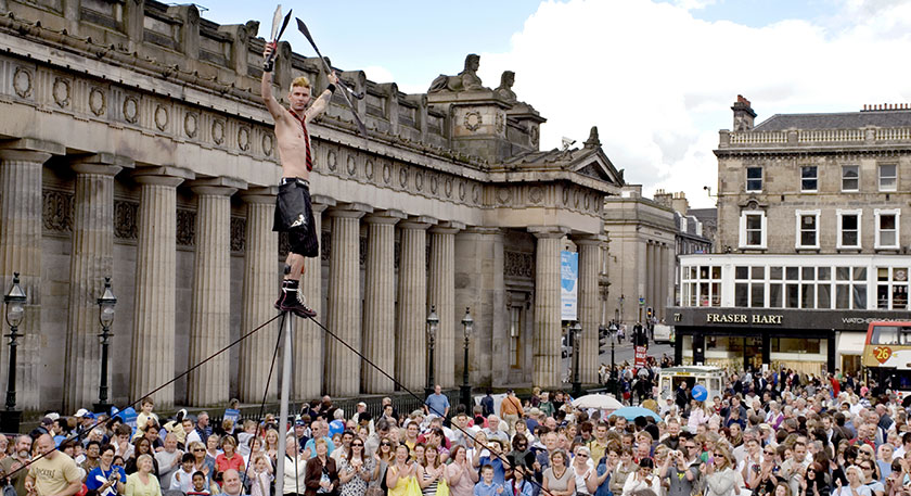 A Edinburgh Festival Fringe performer juggling on the Mound.