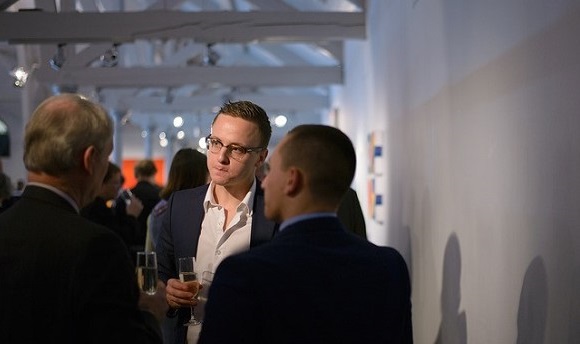 A young man networking with professionals at Dovecot Studio, Edinburgh