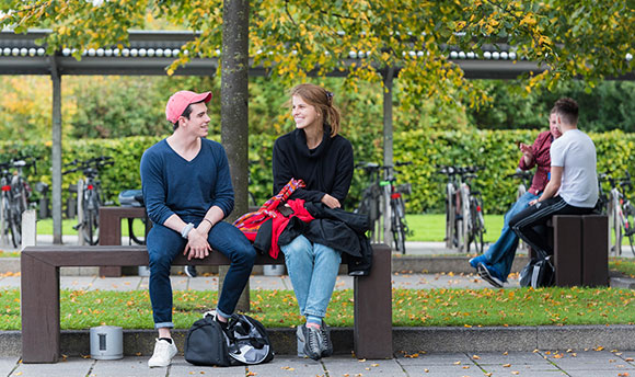 Students talking on the benches outside Queen Margaret University, Edinburgh