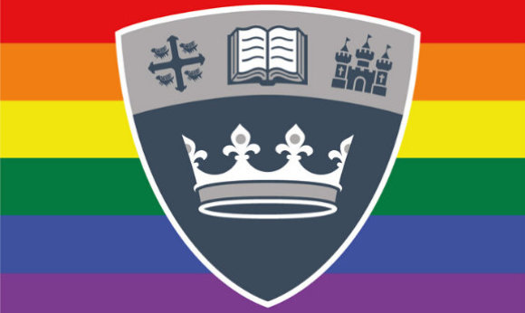 The QMU shield in front of the LGBTQ+ flag