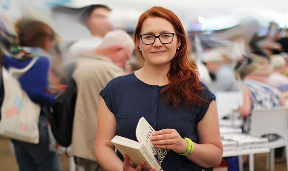 A young ginger woman holding a book