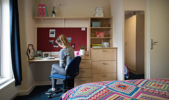 A QMU student at her desk in her student accommodation