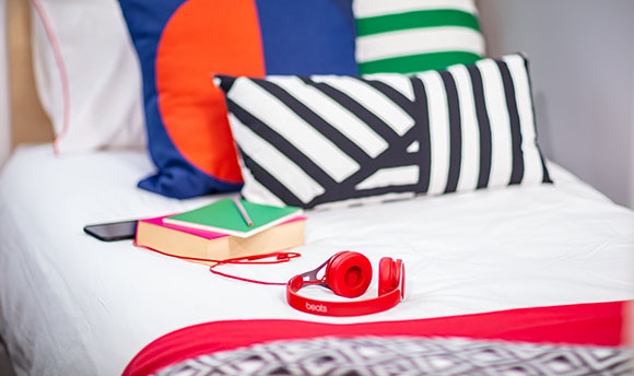 Two books and a pair of headphones lying on a bed in Queen Margaret University campus accommodation